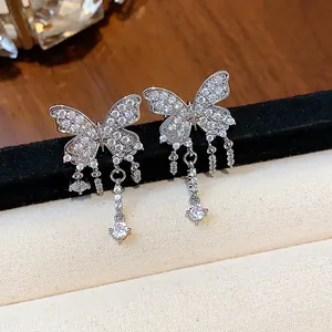 Detailed close-up of shiny zircon-encrusted butterfly earrings with elegant tassel drop.