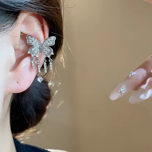 Detail shot of a sparkling zircon butterfly tassel ear cuff worn on the upper ear.