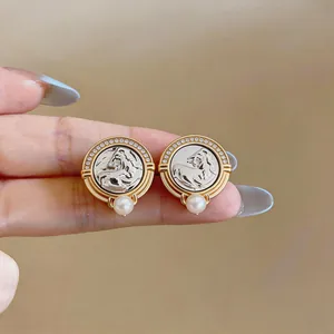 Detail view of vintage style round horse head pearl stud earrings with sparkling zircon halo