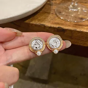 Detailed close-up of vintage style horse head stud earrings with zircon and pearl accents