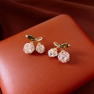 Nahaufnahme der eleganten 14K vergoldeten Kirsch-Ohrstecker mit funkelnden Zirkoniasteinen
