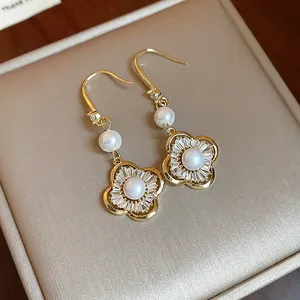 Vue macro de boucles d'oreilles vintage avec fleurs en zircon et perles blanches