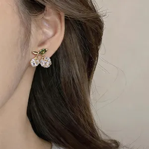Detailansicht eleganter, 14K vergoldeter Kirsch-Ohrstecker mit klaren Zirkonia-Steinen.