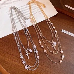 Elegant multi-layer pearl beaded necklace featuring a rhinestone-encrusted cross pendant