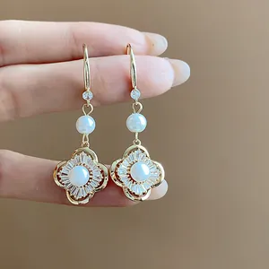 Gros plan détaillé des boucles d'oreilles pendantes vintage fleur en zircon et perle