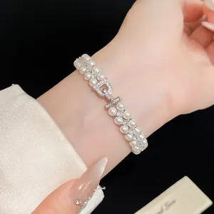 Close-up of elegant double-layer pearl bracelet with D-shaped rhinestone clasp