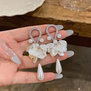 Dettaglio degli orecchini retrò in zircone con perle e petali a forma di goccia