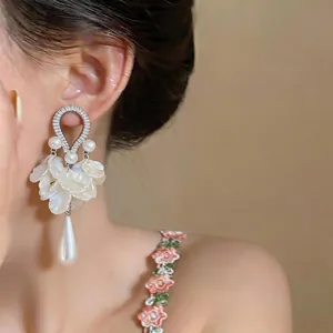 Elegante vista ravvicinata di orecchini di zirconi e perle a petalo su una modella