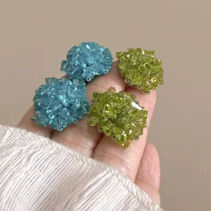 Détail des boucles d'oreilles en perles de cristal bleues et vertes faites main