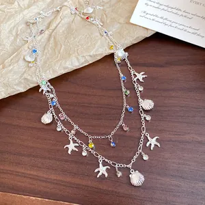 Détail du collier double rang avec breloques coquillages, étoiles de mer et pierres colorées