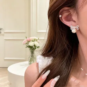 Dettaglio dell'orecchino a fiocco in argento con perla sull'orecchio del modello elegante