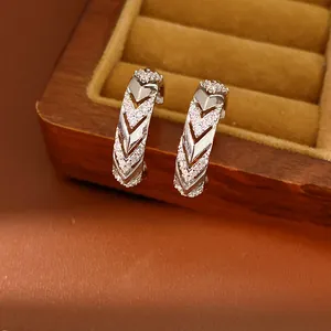 Detailed view of silver-plated C-shaped earrings with chevron pattern and micro zircons