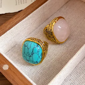 Detailed macro view of vintage gold textured rings with pink quartz and turquoise stones
