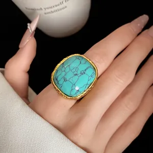 Close-up detail of a vintage gold ring featuring a large square turquoise stone