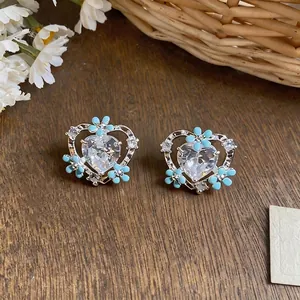Elegant heart-shaped stud earrings featuring delicate blue flowers and sparkling crystals