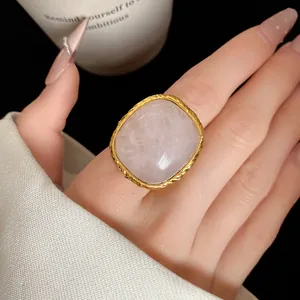 Detailed macro view of a vintage square pink crystal ring featuring a textured golden frame