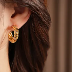 Premium close-up of a 14k gold plated C-shape earring with zircon stones on ear