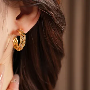 Close-up view of 14k gold plated C-shape hoop earrings set with sparkling cubic zirconia.