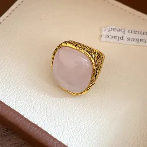 Detailed macro view of a vintage gold textured ring featuring a square pink crystal