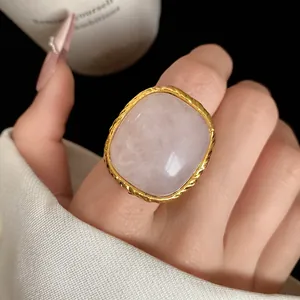 Macro view of vintage square rose quartz ring with ornate gold-tone textured frame