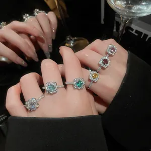 Detailed view of luxury sparkling zircon flower open rings in various colors on hand