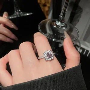 Close-up of elegant flower ring featuring a pink central zircon and silver-toned band