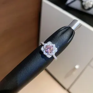 Detailed macro view of a sparkling flower-shaped open ring with pink zircon center.