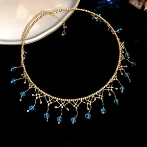 Detailed macro view of a vintage gold lace choker with elegant blue crystal tassels.