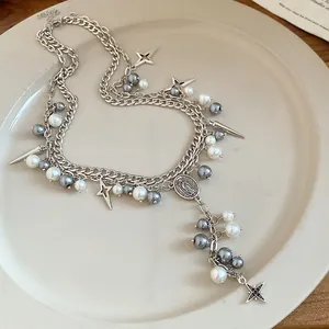 Close-up of double-layered silver chain necklace with pearls and religious medallion