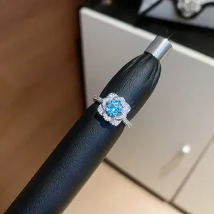 Detailed macro shot of a shiny silver-plated open ring with a light blue zircon flower