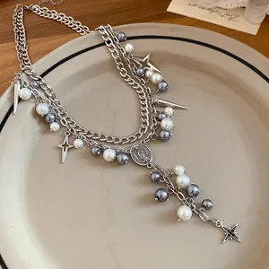 Close-up of double-layered necklace with mixed pearls and star charms on a plate.