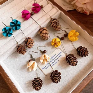 Handmade vintage forest style earrings featuring flower and pinecone pendants in a wooden box