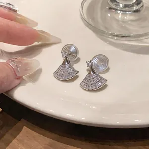 Primo piano di eleganti orecchini a clip a ventaglio con zirconi e placcatura in oro 18 carati.