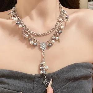 Layered silver necklace featuring grey and white pearls with star charms and oval medallion.