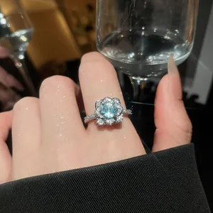 Detailed close-up of a sparkling light blue zircon flower ring with elegant pavé setting