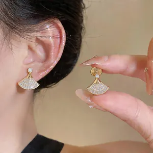 Dettaglio di orecchini a clip a ventaglio placcati oro 18k con zirconi lucidi da donna