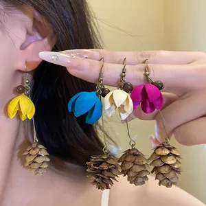 Detailed view of forest-style vintage earrings with colorful flowers and pinecone pendants