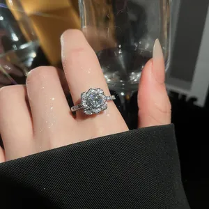 Detailed macro view of a sparkling camellia flower ring with zircon stones on finger