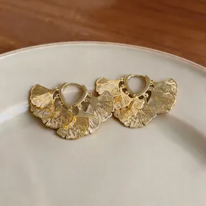 Elegante goldene Ginkgoblatt-Ohrringe mit detaillierter metallischer Texturansicht