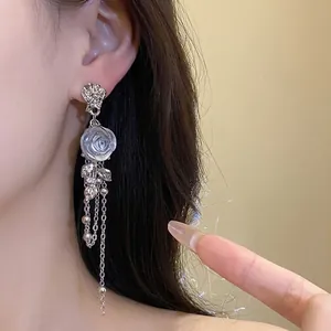 Elegant silver-toned rose earrings with long chain tassels and resin flower detail
