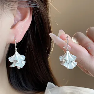 Dettaglio di orecchini a gancio in argento con design a foglia pieghettata elegante