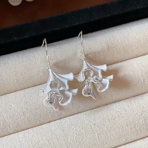 Dettaglio degli orecchini a foglia pieghettata in argento con elegante design a balze
