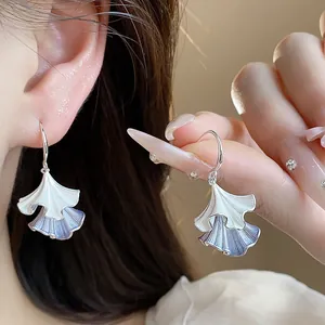 Primo piano di eleganti orecchini a foglia increspata con finitura in smalto blu e bianco