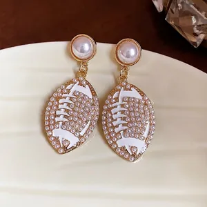 Elegant football-shaped white enamel earrings with pearl accents in vintage style.