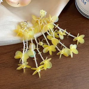 Detail shot of elegant yellow tassel earrings featuring translucent floral sequins.