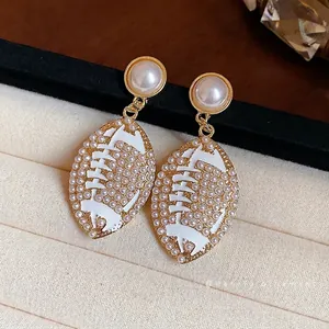 Elegant pearl stud earrings with vintage football drop design and white enamel finish