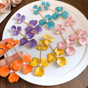 Detailansicht farbenfroher großer Blumenohrringe mit Perlen und Stahlnadeln für Damen.