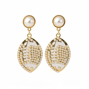 Elegant gold-tone football-shaped drop earrings with faux pearls and white enamel finish