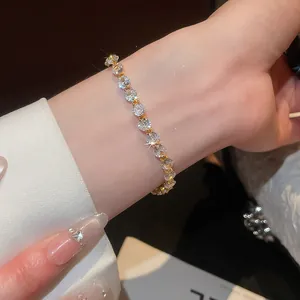 Primo piano di un lussuoso bracciale in zircone placcato oro 18k con pietre rotonde brillanti