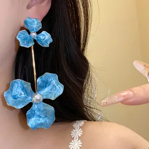 Detailansicht der übergroßen blauen Emaille-Blumenohrringe mit eleganten Perlenakzenten